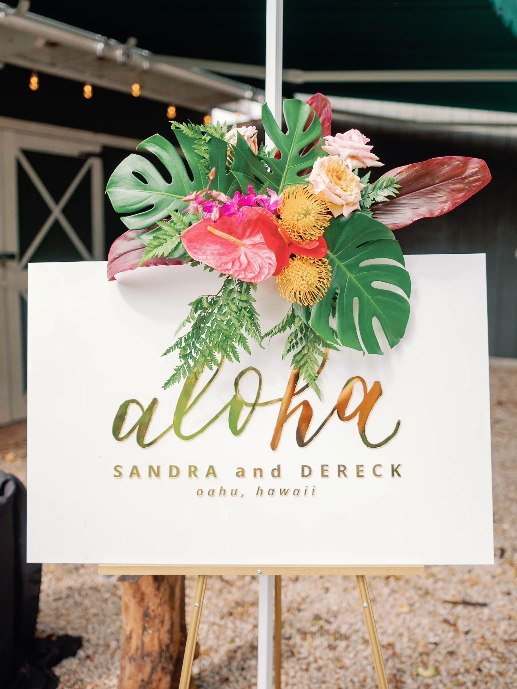 Tropical floral arrangement with monstera, anthurium, pincushion protea, and roses on a wedding sign at Loulu Palms, Oʻahu. — Wedding Event Oahu Hawaii Florals Flowers Florist Creative Concepts by Jeff Alencastre